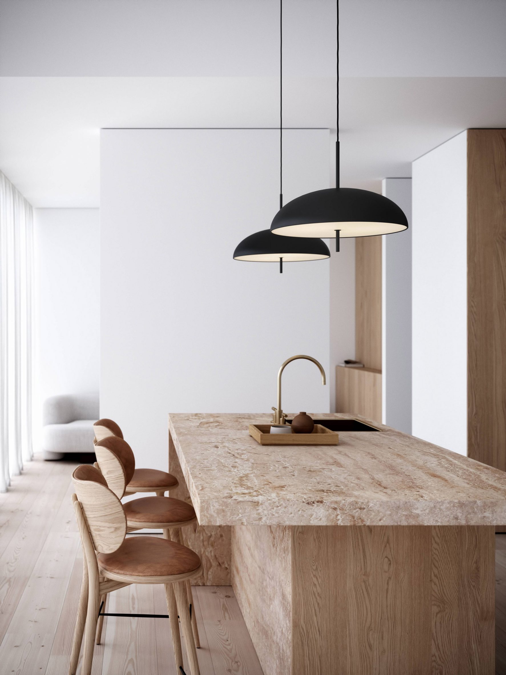 Two black pendant lamps hung over a wood kitchen island with a sink and wooden chairs