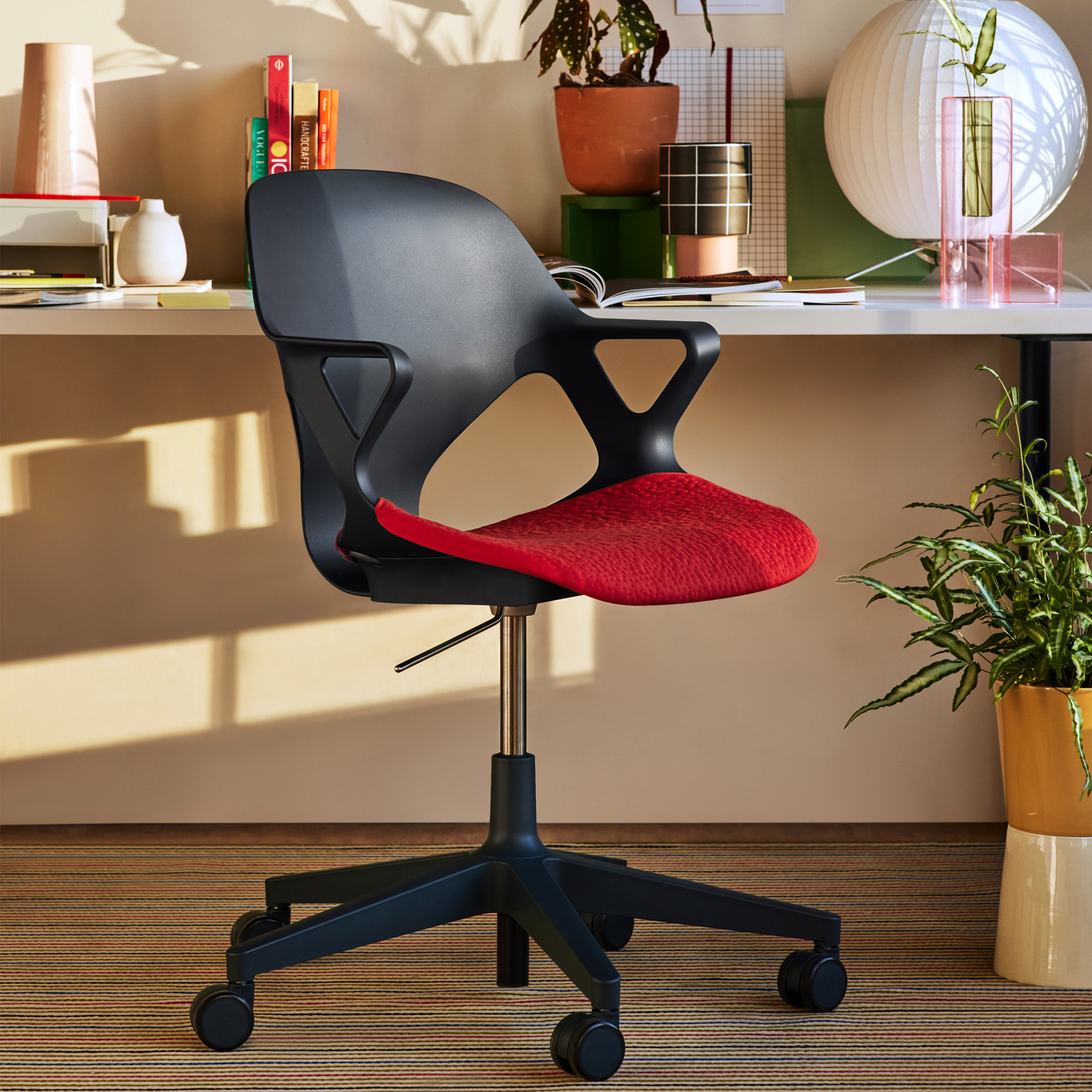 Black Zeph Chair with red upholstered seat at a home desk