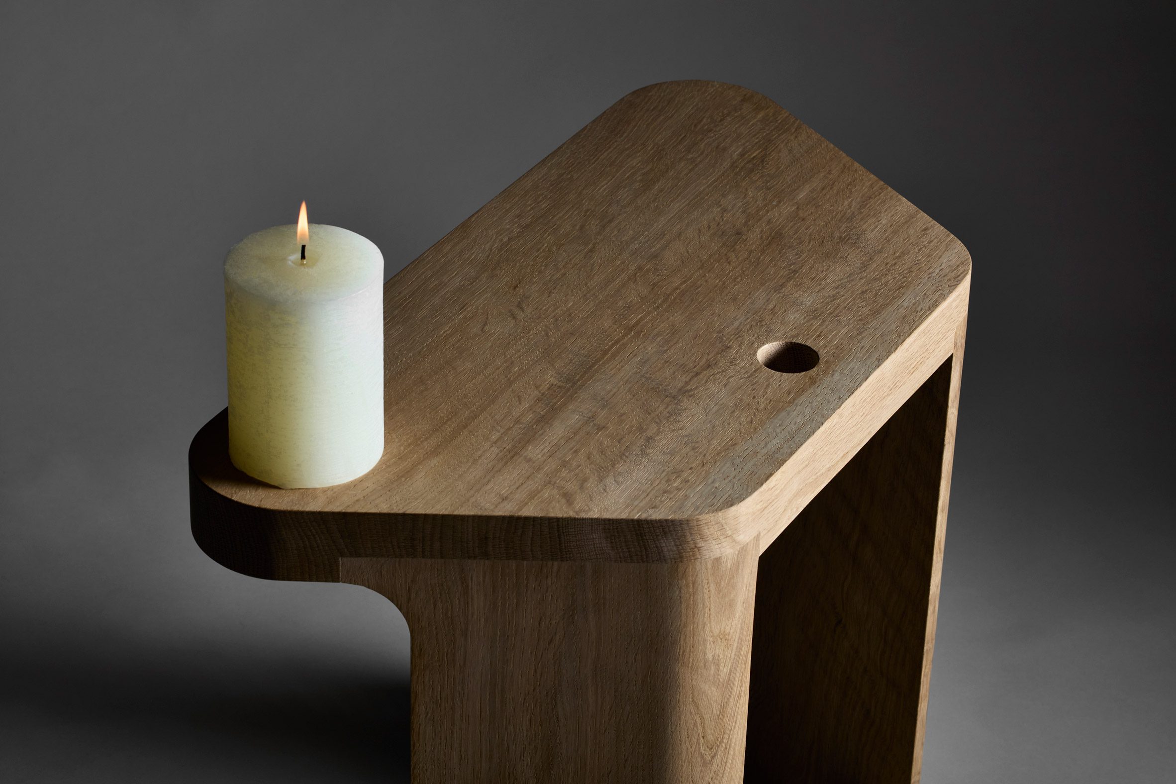 Close-up of Pew stool by EJM Studio with candle on top